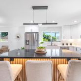 a large kitchen with stainless steel appliances granite countertop a stove a sink a dining table and chairs