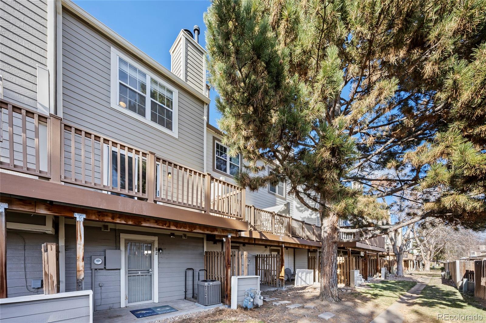 1811 South Quebec Way, Unit 82 Denver, CO 80231 - Photo 30 of 35 a building with a tree in front of it