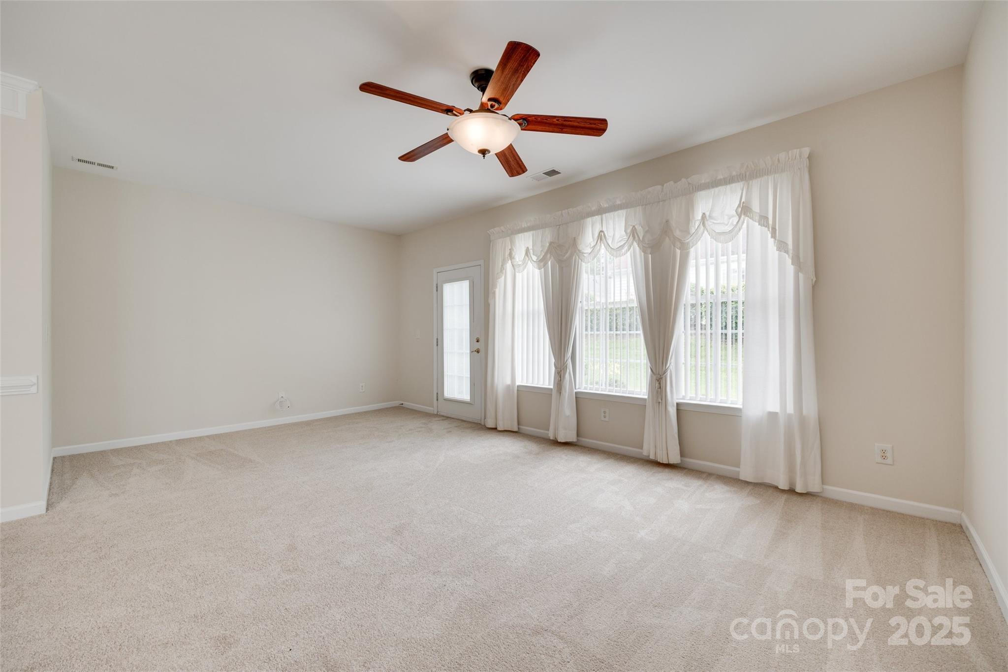 422 Garnet Court Fort Mill, SC 29708 - Photo 14 of 45 an empty room with chandelier fan and windows