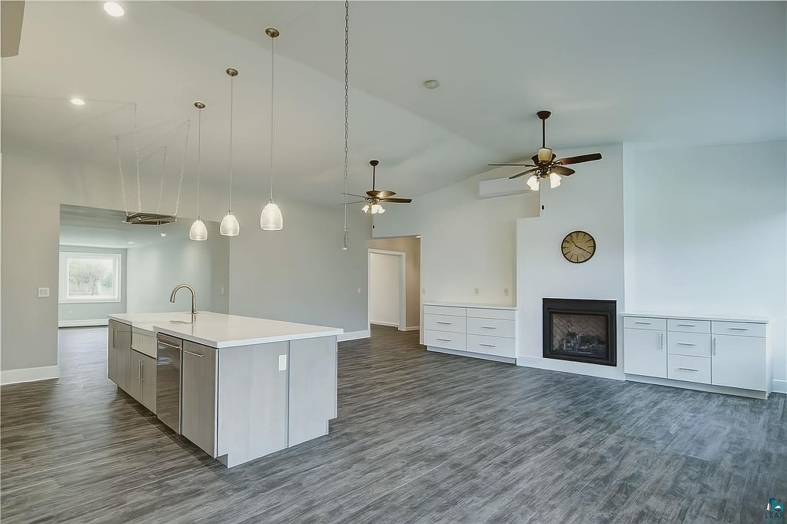 6030 Mitchell Road Iron River, WI 54847 - Photo 45 of 45 Kitchen with open floor plan, a fireplace, decorative light fixtures, dark wood-type flooring, and white cabinetry