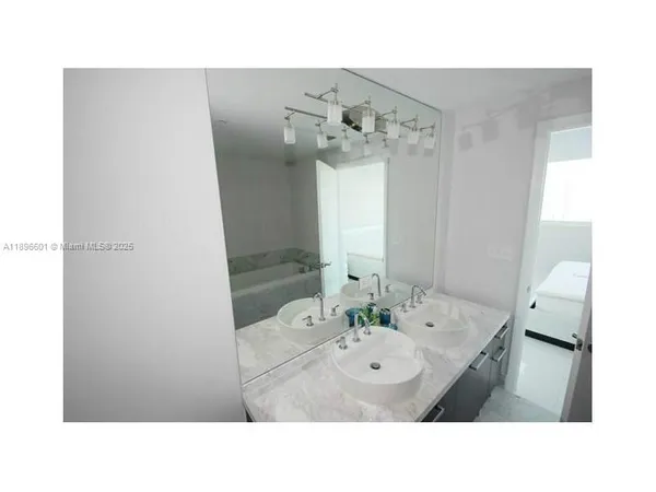 a bathroom with a sink tub and shower