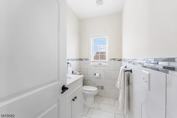 a bathroom with a granite countertop toilet a sink and a bathtub