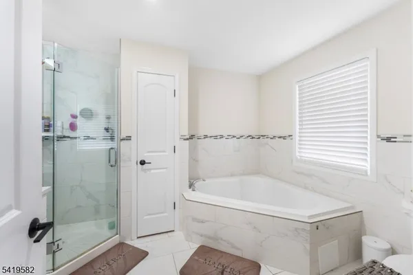 a white bath tub sitting next to a shower