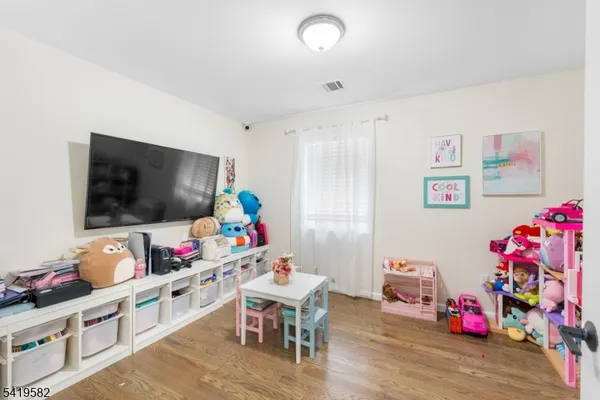 a playing room with furniture and a flat screen tv