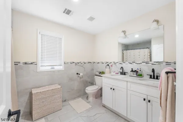 a spacious bathroom with a toilet sink and mirror