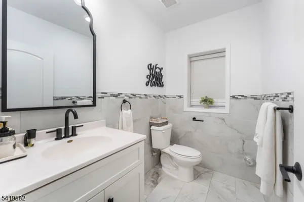 a bathroom with a sink a toilet and a mirror