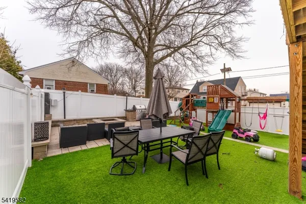 a backyard of a house with table and chairs