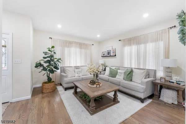 a living room with furniture a table and a potted plant