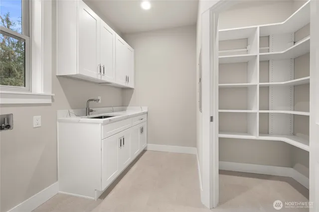 a kitchen with white cabinets and white appliances