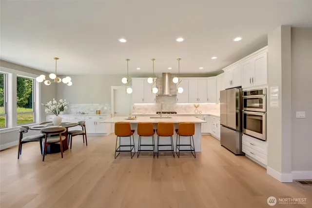 a kitchen with stainless steel appliances kitchen island granite countertop a sink and a refrigerator