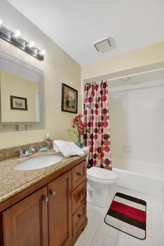 an aerial view of a house with swimming pool and large trees