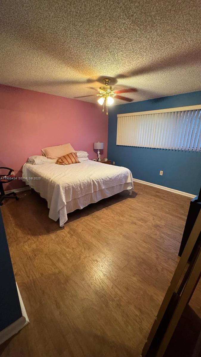 15039 Southwest 89th Ter Road Miami, FL 33196 - Photo 13 of 21 a bed sitting in a room next to a lamp