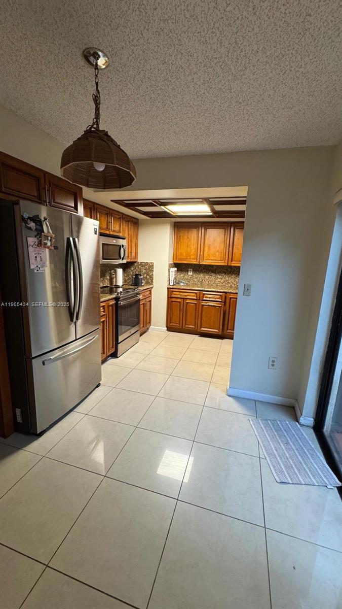 15039 Southwest 89th Ter Road Miami, FL 33196 - Photo 17 of 21 a kitchen with granite countertop a stove a refrigerator and a counter top space