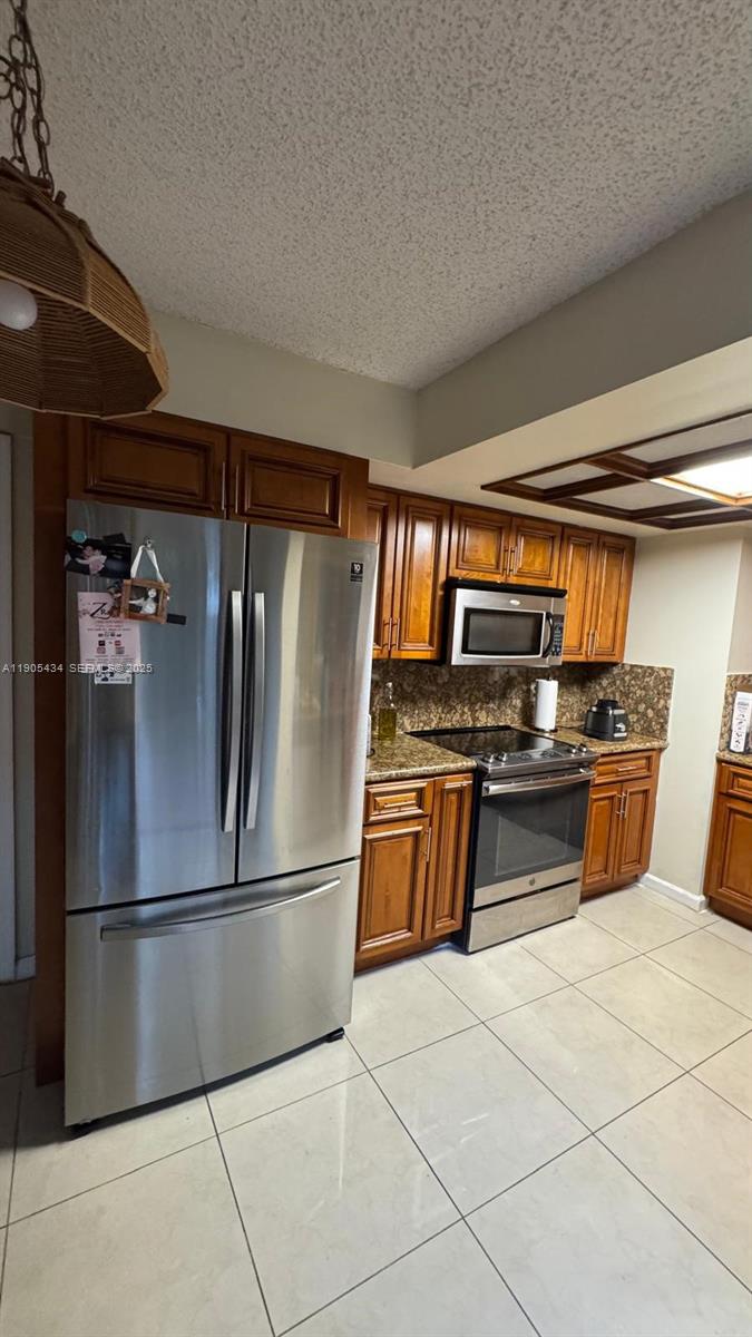 15039 Southwest 89th Ter Road Miami, FL 33196 - Photo 18 of 21 a kitchen with stainless steel appliances granite countertop a refrigerator and a stove top oven