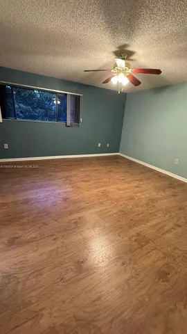 a view of a room with a fan and wooden floor