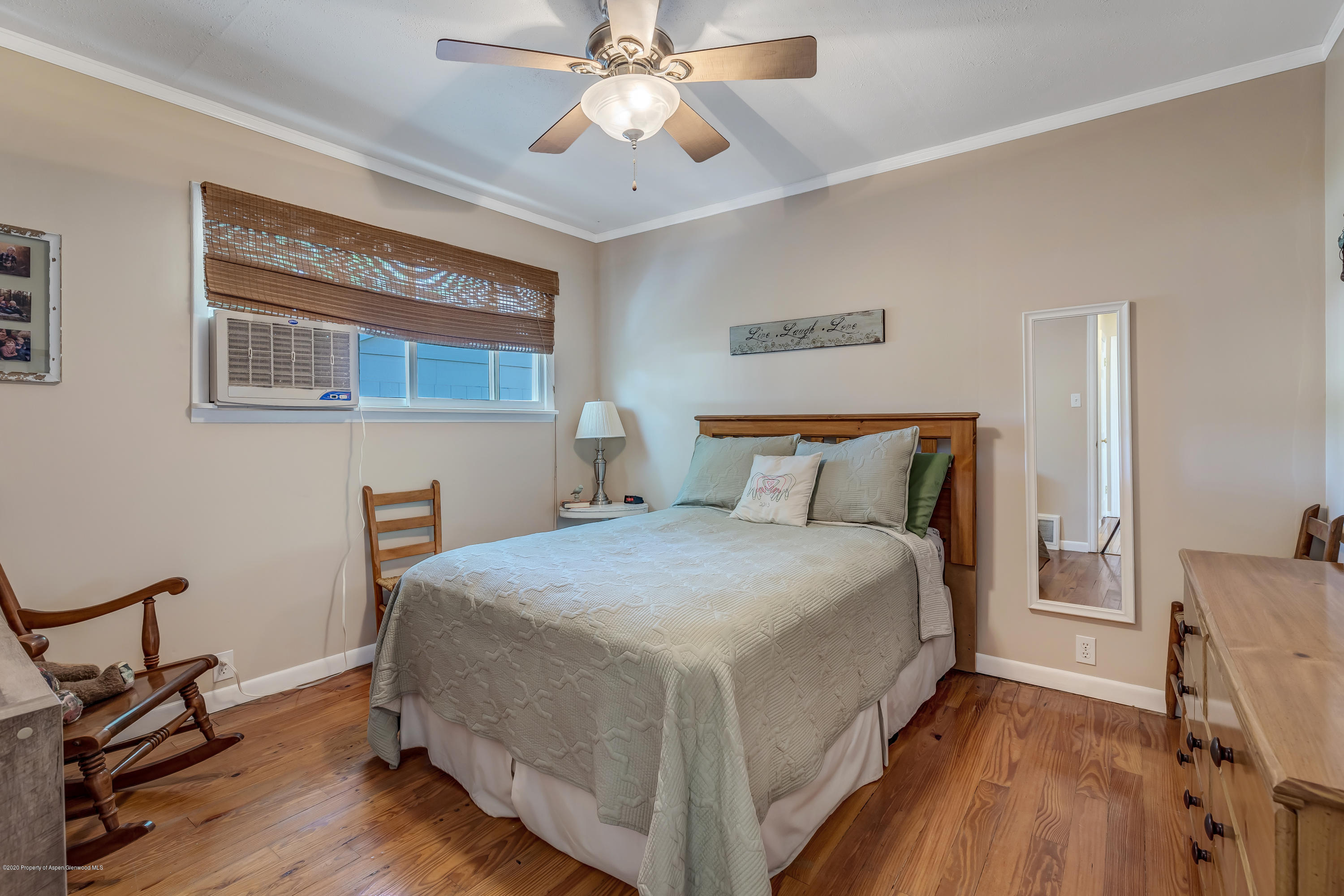 217 Ash Avenue Rifle, CO 81650 - Photo 11 of 25 a bedroom with a bed and a chandelier