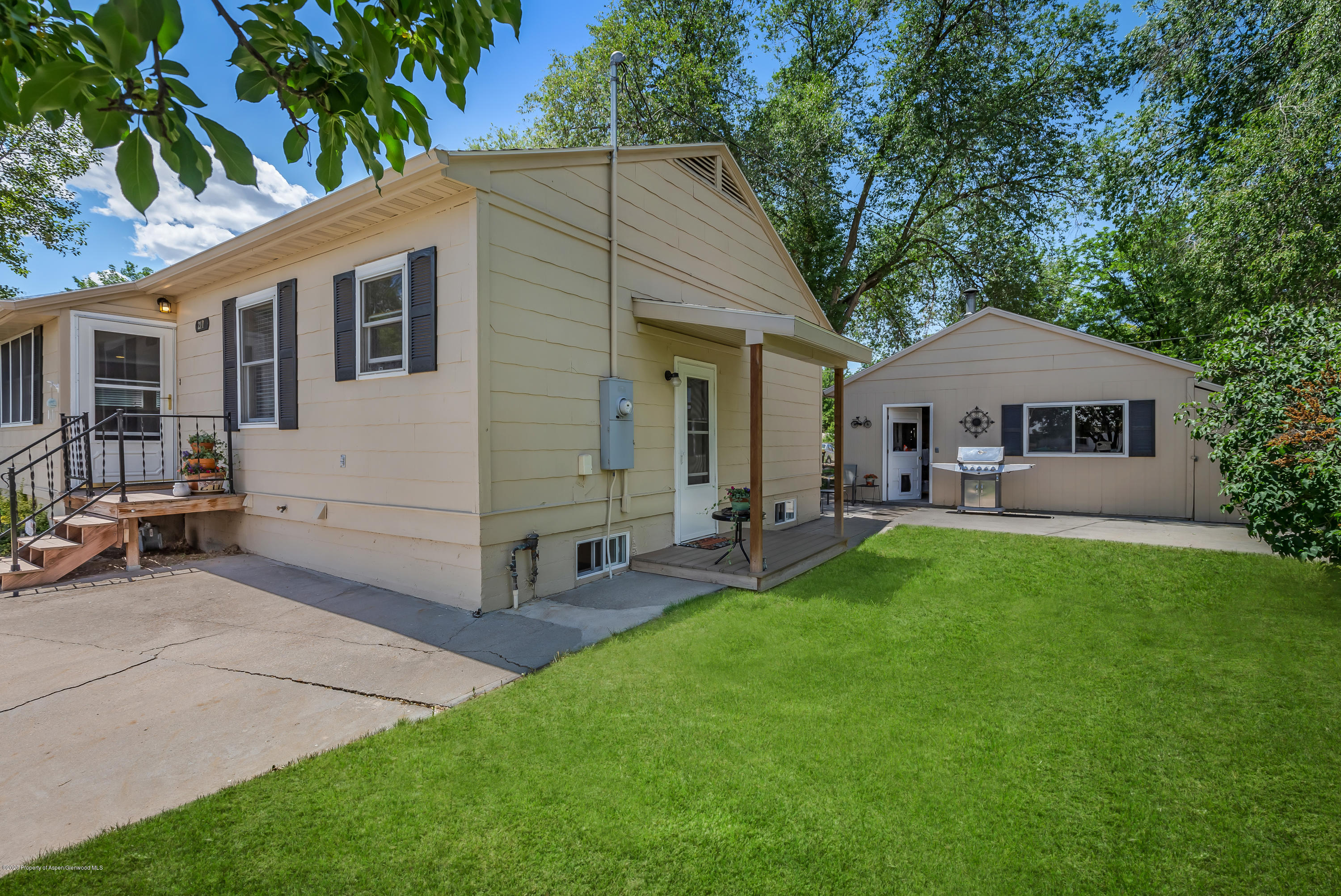 217 Ash Avenue Rifle, CO 81650 - Photo 3 of 25 a front view of a house with a garden and trees