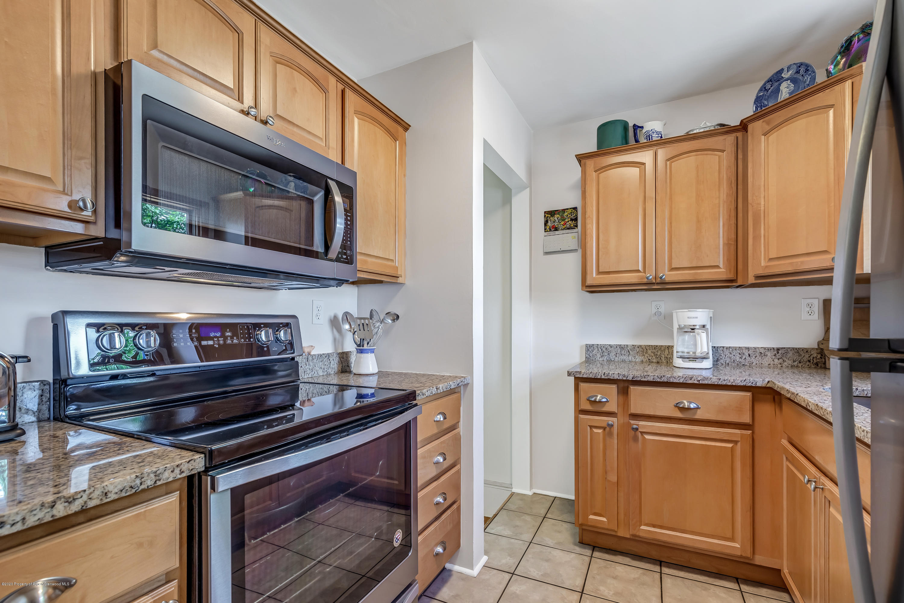 217 Ash Avenue Rifle, CO 81650 - Photo 6 of 25 a kitchen with stainless steel appliances granite countertop a stove microwave and sink