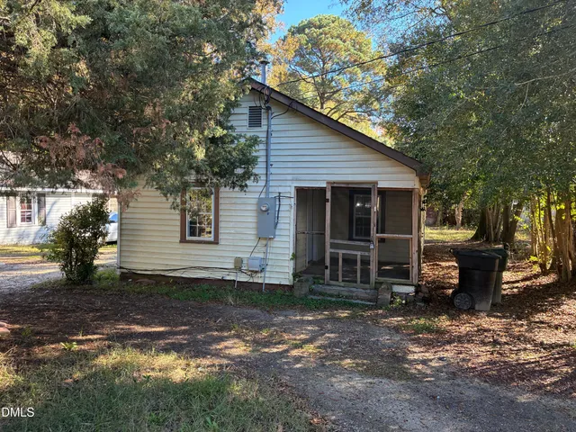 a view of a house with a yard and large tree