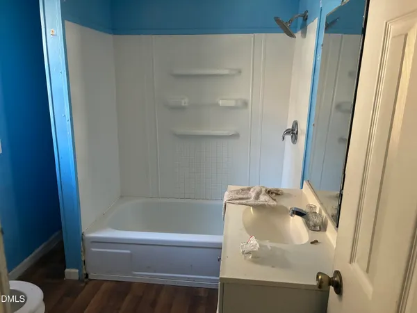 a bath tub sitting next to a white sink and vanity