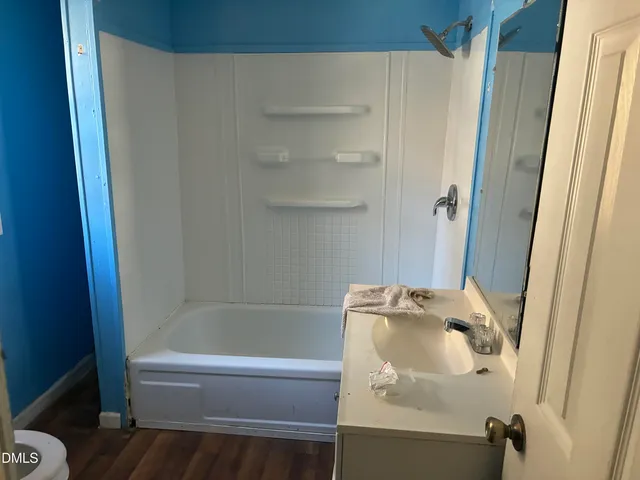 a bath tub sitting next to a white sink and vanity
