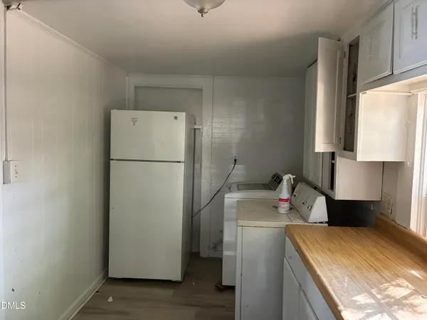 a room with a refrigerator and a stove top oven
