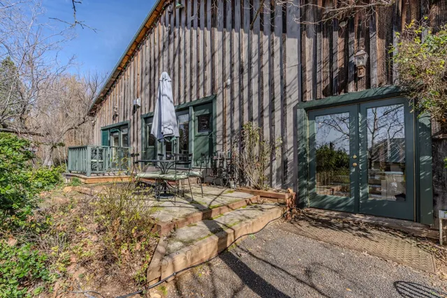 a view of a dining room with furniture a chandelier and large window