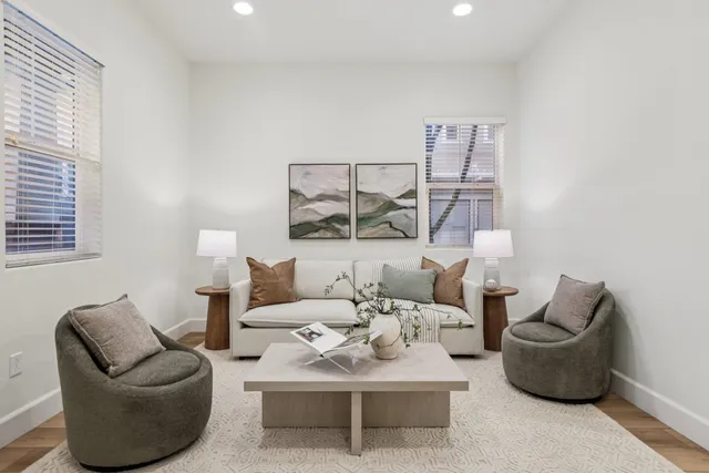 a living room with furniture a lamp and a large window