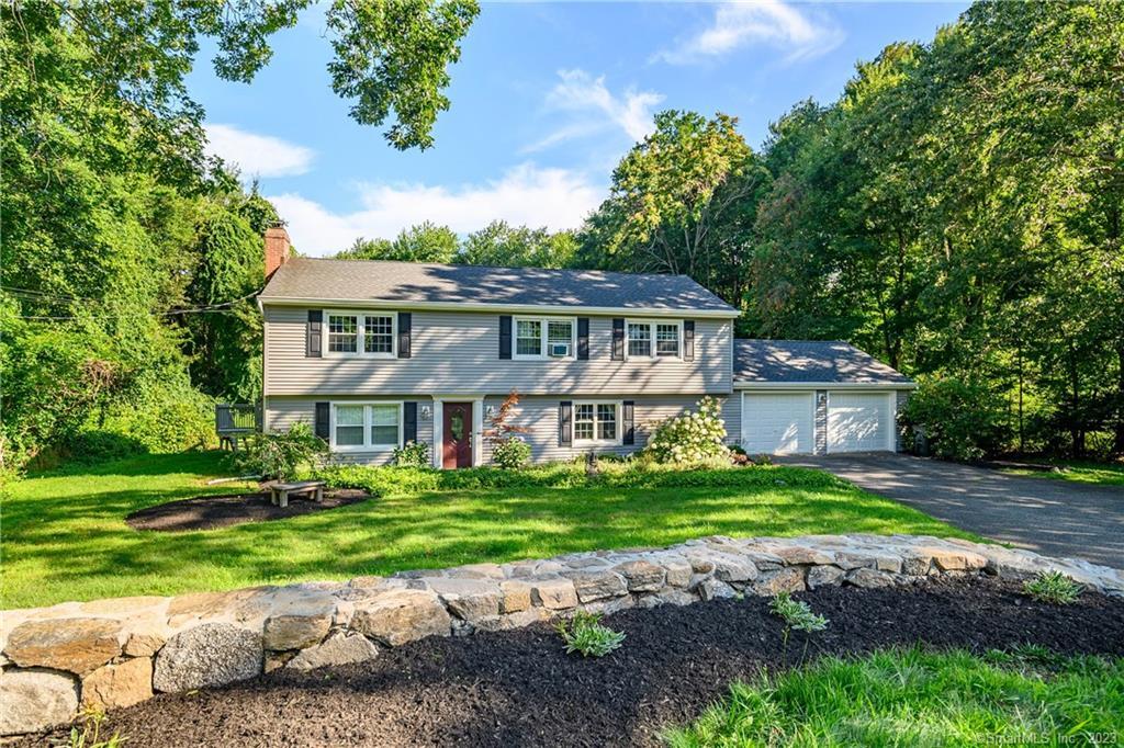 130 Castle Hill Road Newtown, CT 06470 - Photo 1 of 1 a front view of a house with a garden and trees