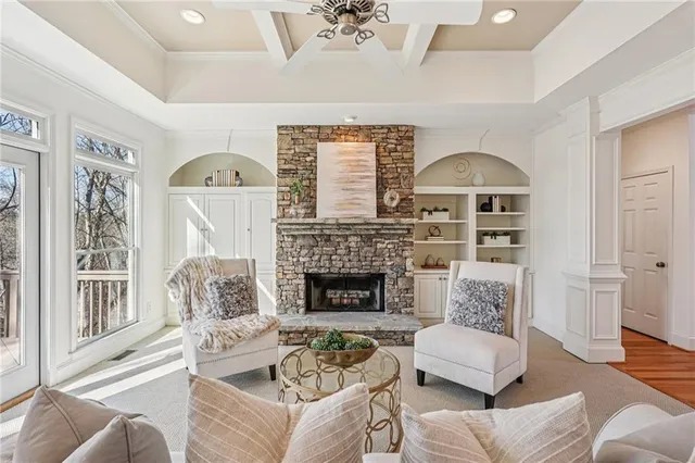a living room with furniture a fireplace and a large window