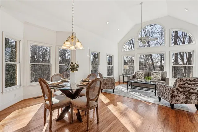 a dining room with furniture a chandelier and wooden floor