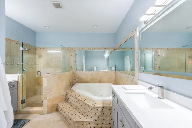 a bathroom with a bathtub shower sink and mirror