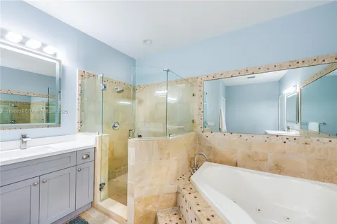 a bathroom with a tub a sink shower and mirror