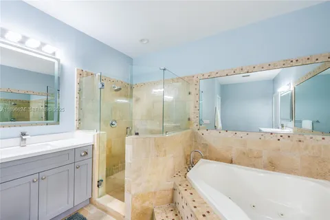 a bathroom with a tub a sink shower and mirror