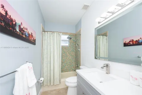 a bathroom with a sink a toilet and shower curtain
