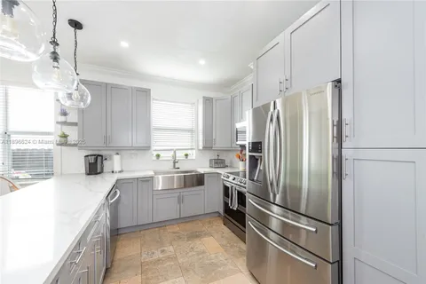a kitchen with stainless steel appliances granite countertop a refrigerator sink and stove