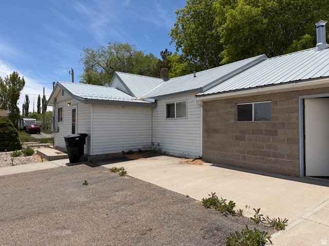 1043 East 4000th Street South Vernal, UT 84078 - Photo 3 of 31 Property exterior featuring a metal roof, white horizontal siding, and a concrete block addition