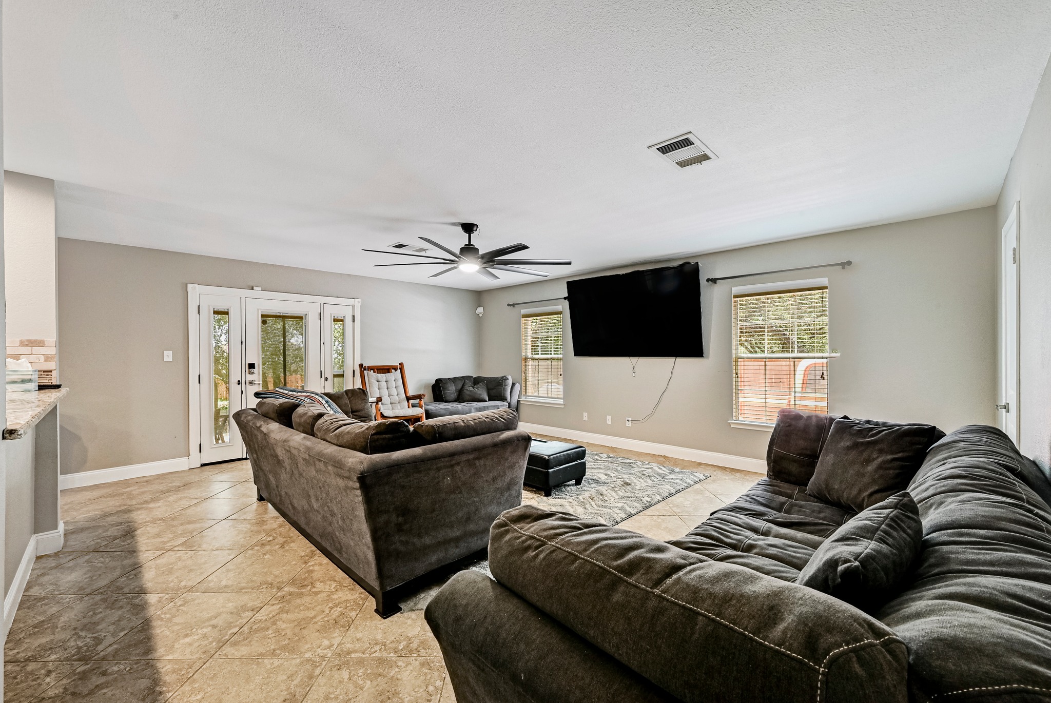 104 North Sumac Lane Georgetown, TX 78633 - Photo 10 of 40 Ceramic tile flooring spans this generous living room, offering direct access to the outdoors.