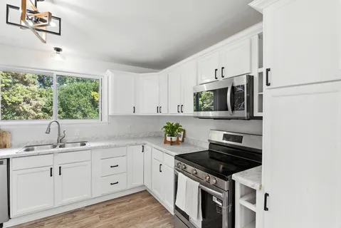 a kitchen with stainless steel appliances a sink stove and cabinets