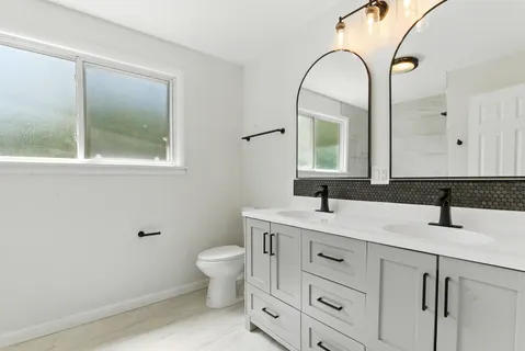 a bathroom with a toilet sink and mirror