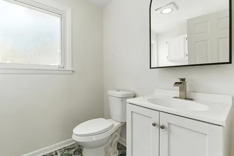 a bathroom with a sink a toilet and a mirror