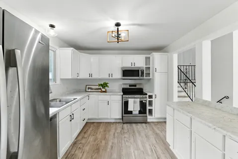 a kitchen with stainless steel appliances granite countertop a refrigerator a stove top oven a sink and dishwasher