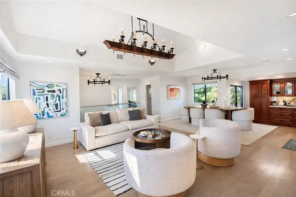 a living room with furniture kitchen view and a window
