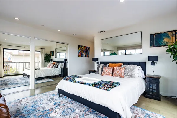 a bedroom with a large bed and a flat tv screen