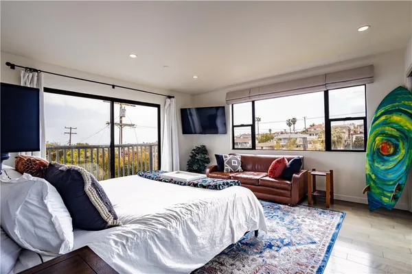 a bedroom with a bed and large windows