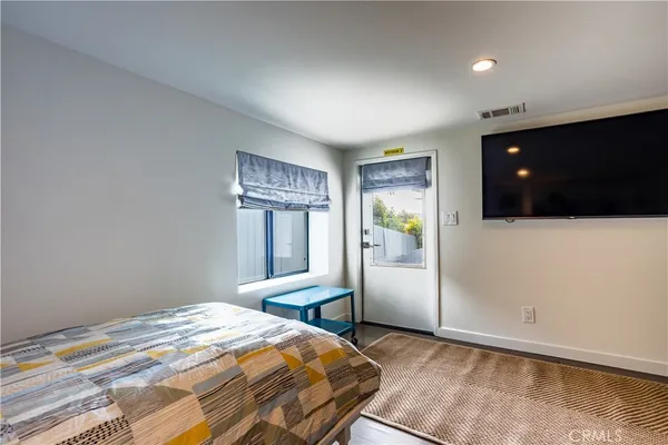 a bedroom with a bed and a flat screen tv