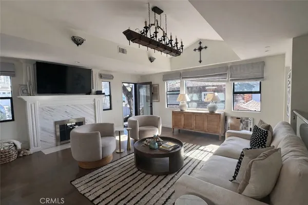 a living room with furniture a flat screen tv and a fireplace