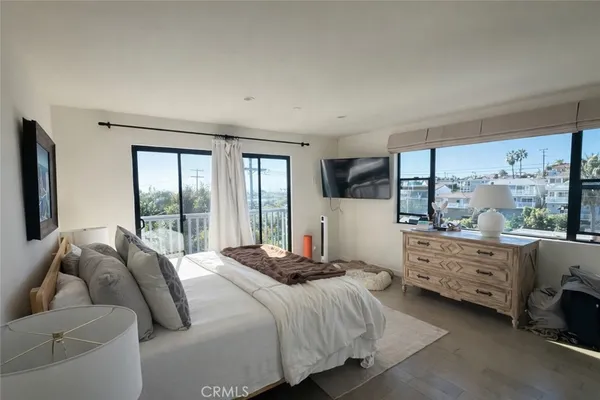 a bedroom with a bed and large windows
