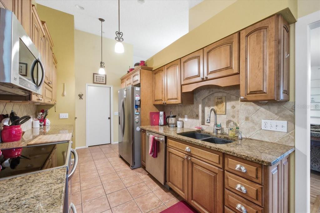 9338 Clearmeadow New Port Richey, FL 34655 - Photo 13 of 54 a kitchen with stainless steel appliances granite countertop a sink stove and cabinets