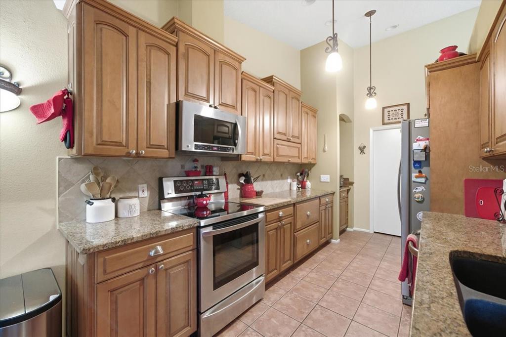 9338 Clearmeadow New Port Richey, FL 34655 - Photo 14 of 54 a kitchen with kitchen island granite countertop a sink stainless steel appliances and cabinets